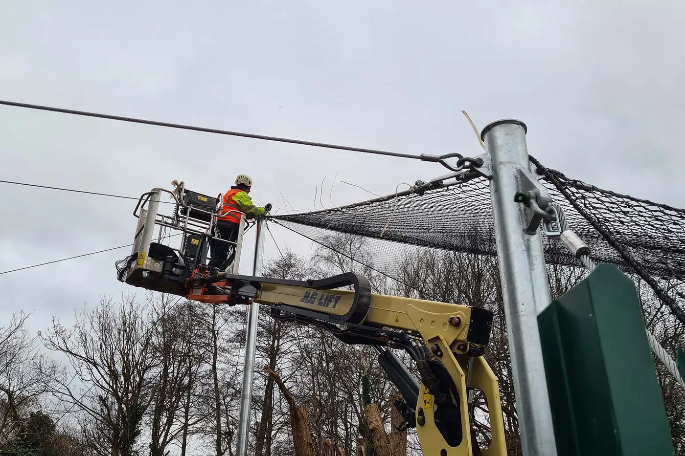 Technician installing tensile roof canopy using rope access